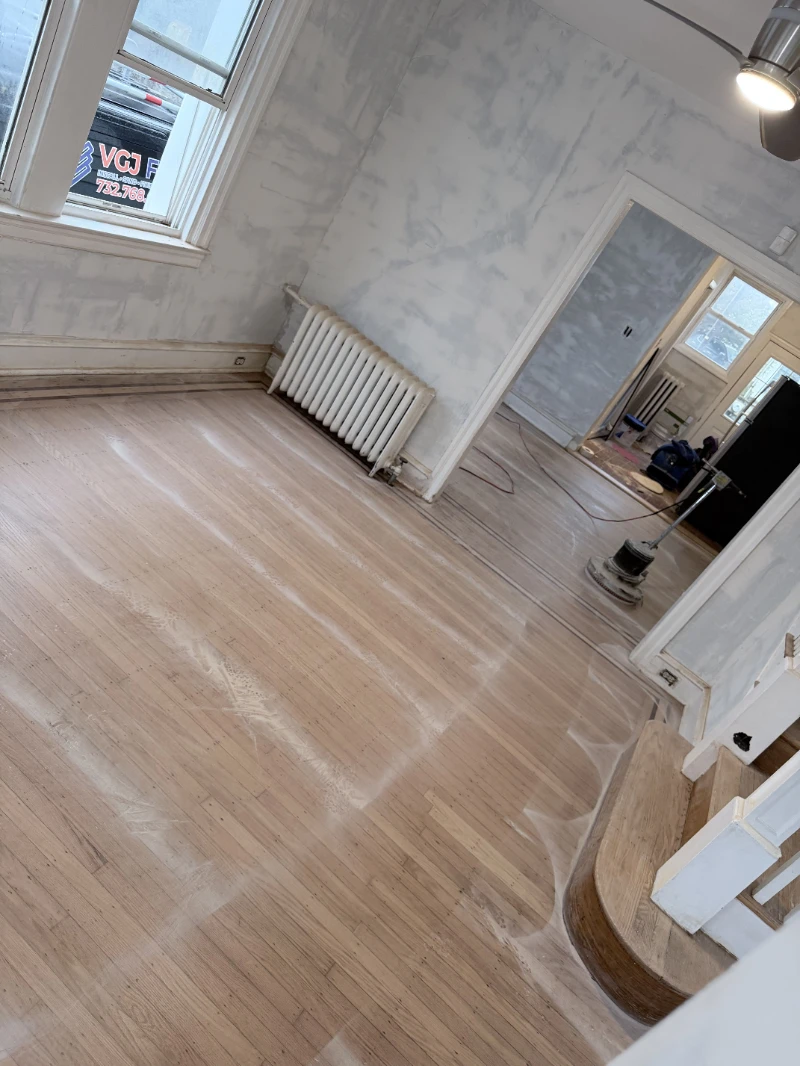 Living room floor sanded back to bare wood, buffer standing by and the radiator still in place